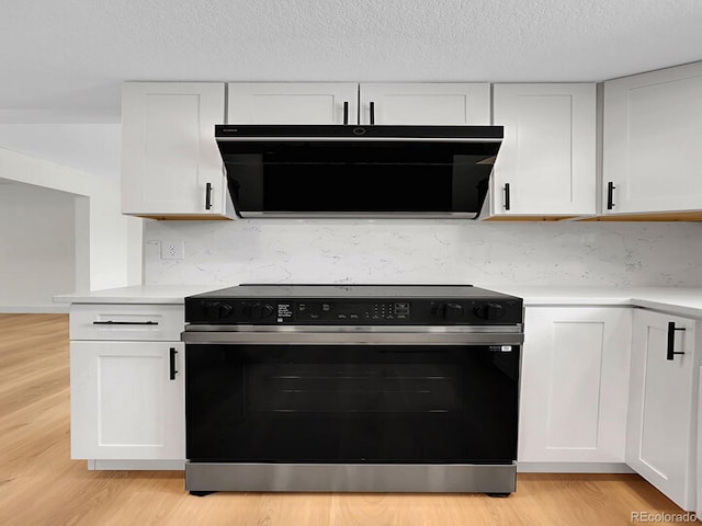 8694 E Eastman Ave, Denver, CO 80231 - kitchen featuring black range with electric stovetop, light countertops, white cabinets, light wood-type flooring, and a textured ceiling