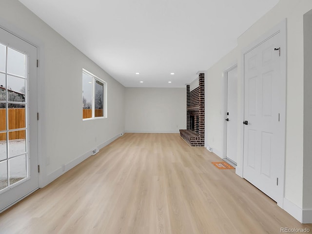 8694 E Eastman Ave, Denver, CO 80231 - unfurnished living room featuring plenty of natural light, a fireplace, light wood finished floors, and recessed lighting