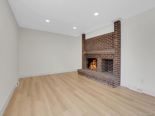 8694 E Eastman Ave, Denver, CO 80231 - unfurnished living room with a brick fireplace, wood finished floors, recessed lighting, and baseboards