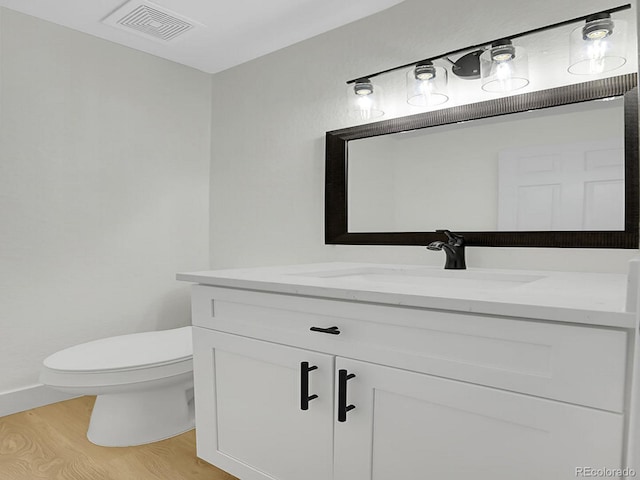 8694 E Eastman Ave, Denver, CO 80231 - bathroom with vanity, toilet, wood finished floors, and baseboards