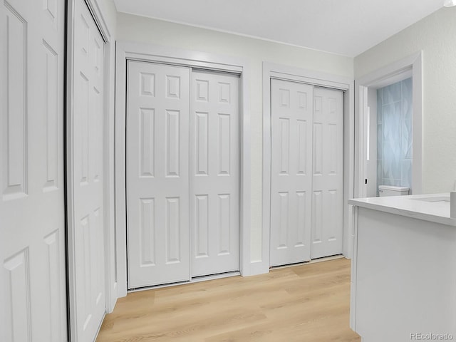 8694 E Eastman Ave, Denver, CO 80231 - unfurnished bedroom featuring light wood-style floors and multiple closets