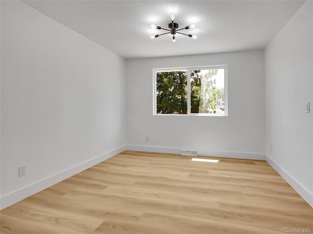 8694 E Eastman Ave, Denver, CO 80231 - unfurnished room with a chandelier and wood finished floors