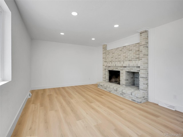8694 E Eastman Ave, Denver, CO 80231 - unfurnished living room featuring wood finished floors, recessed lighting, and a brick fireplace