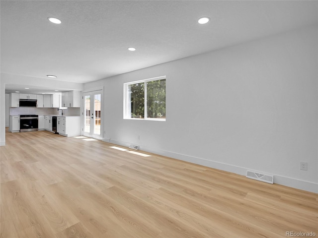 8694 E Eastman Ave, Denver, CO 80231 - unfurnished living room with french doors, recessed lighting, and light wood-style flooring