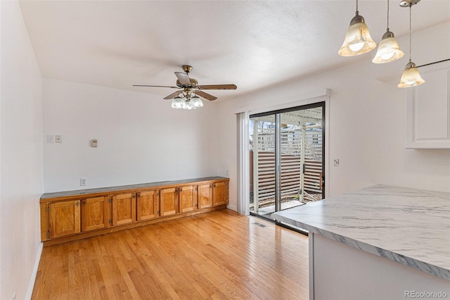 unfurnished dining area with light hardwood / wood-style floors and ceiling fan