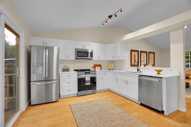 1717 Tulip St, Longmont, CO 80501 - kitchen with appliances with stainless steel finishes, vaulted ceiling, light countertops, light wood-style flooring, and white cabinets