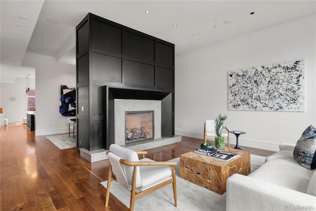 living room featuring dark wood-type flooring and a large fireplace