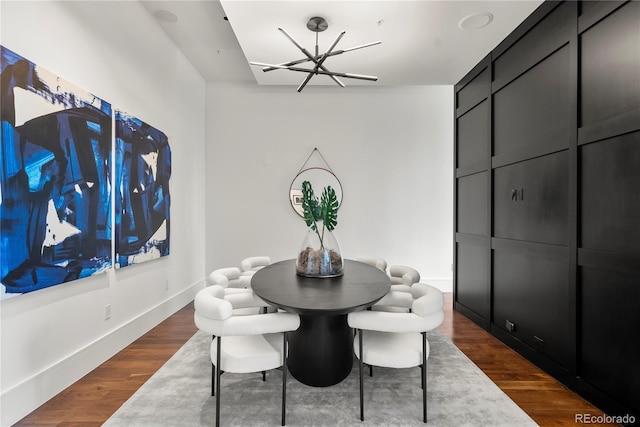 dining area with hardwood / wood-style floors and an inviting chandelier