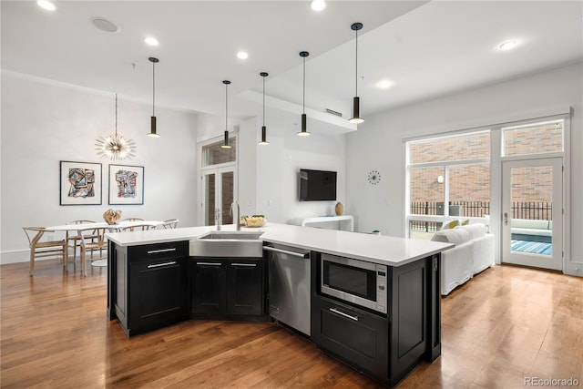 kitchen featuring pendant lighting, a center island, appliances with stainless steel finishes, and sink