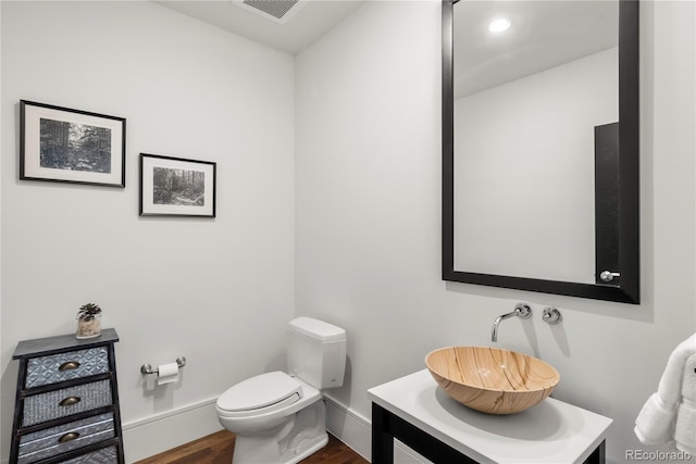 bathroom with hardwood / wood-style floors, toilet, and vanity