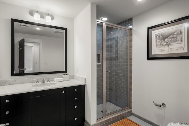 bathroom featuring a shower with door, tile patterned flooring, and vanity