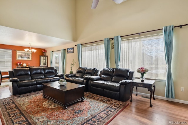 living room featuring wood-type flooring, a healthy amount of sunlight, and a notable chandelier