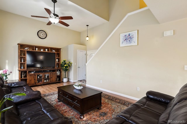 living room with hardwood / wood-style floors, high vaulted ceiling, and ceiling fan