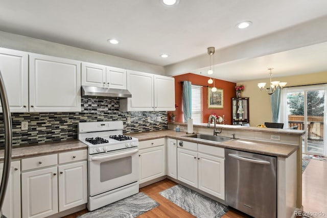 kitchen featuring dishwasher, sink, kitchen peninsula, decorative light fixtures, and white range with gas stovetop