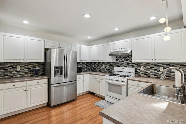 kitchen featuring white gas range, white cabinetry, sink, stainless steel fridge with ice dispenser, and decorative light fixtures