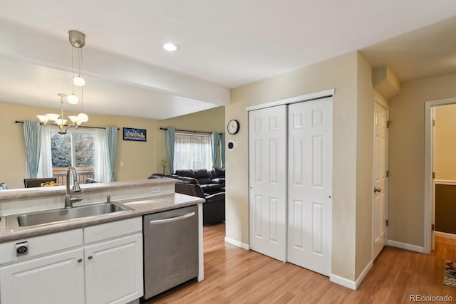 kitchen featuring dishwasher, sink, hanging light fixtures, light hardwood / wood-style floors, and white cabinetry