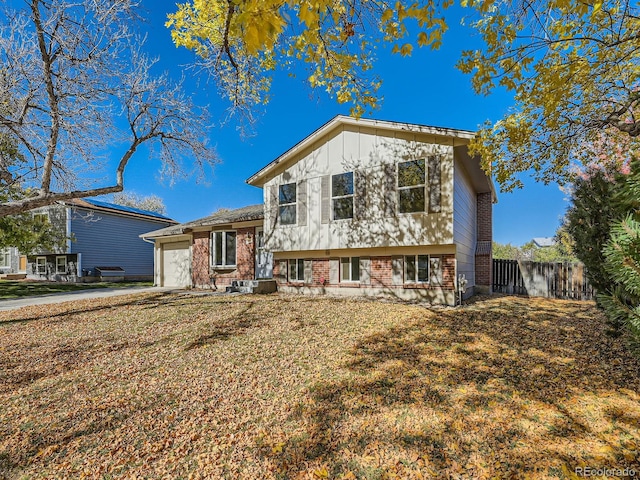 split level home featuring a front lawn and a garage