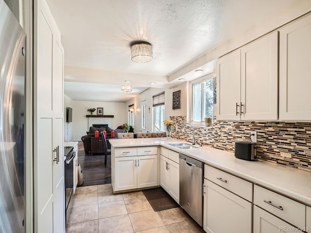7520 Braun Ct, Arvada, CO 80005 - kitchen featuring appliances with stainless steel finishes, light countertops, backsplash, and open floor plan