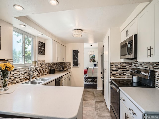 7520 Braun Ct, Arvada, CO 80005 - kitchen featuring appliances with stainless steel finishes, light countertops, decorative backsplash, a peninsula, and recessed lighting