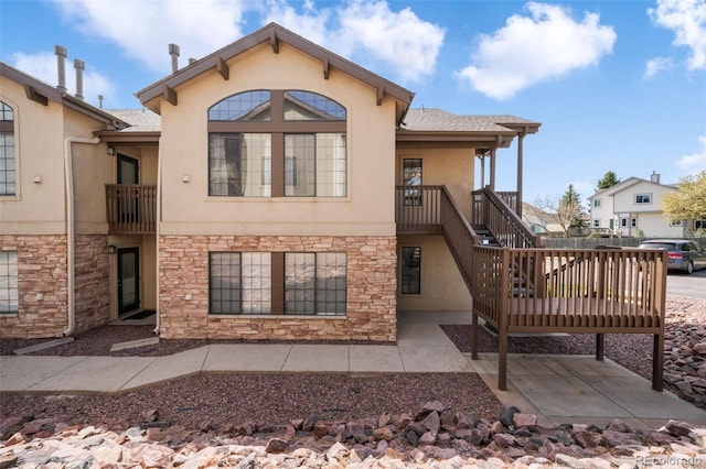 2172 Denton Grv Unit 203, Colorado Springs, CO 80919 - back of property with stone siding, stucco siding, and a patio