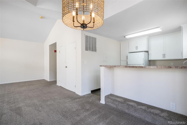 2172 Denton Grv Unit 203, Colorado Springs, CO 80919 - kitchen with freestanding refrigerator, an inviting chandelier, dark colored carpet, visible vents, and vaulted ceiling