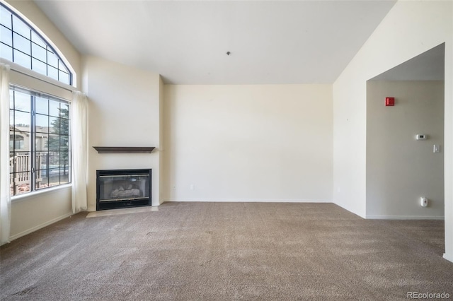 2172 Denton Grv Unit 203, Colorado Springs, CO 80919 - unfurnished living room with carpet flooring, baseboards, and a fireplace with flush hearth
