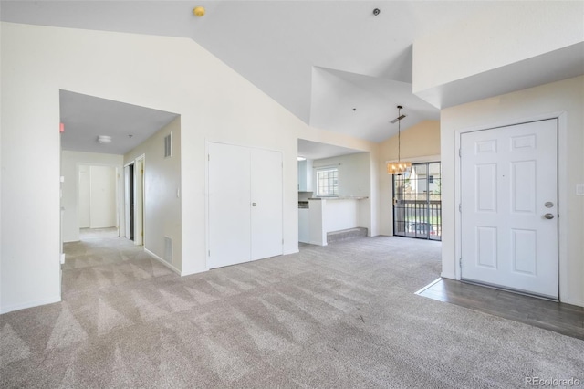2172 Denton Grv Unit 203, Colorado Springs, CO 80919 - unfurnished living room featuring carpet, baseboards, an inviting chandelier, visible vents, and vaulted ceiling