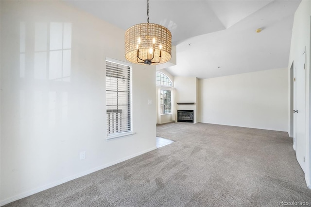 2172 Denton Grv Unit 203, Colorado Springs, CO 80919 - unfurnished living room with lofted ceiling, a chandelier, carpet floors, and a glass covered fireplace