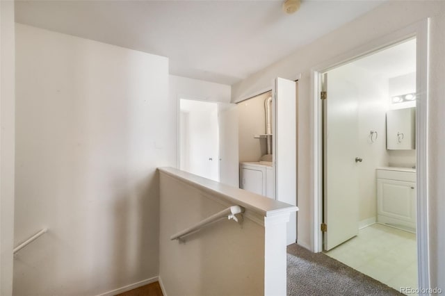 2172 Denton Grv Unit 203, Colorado Springs, CO 80919 - corridor featuring light colored carpet, independent washer and dryer, an upstairs landing, and baseboards