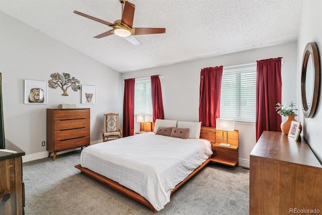 4231 S Fairplay Cir # E, Aurora, CO 80014 - carpeted bedroom featuring a textured ceiling, multiple windows, vaulted ceiling, ceiling fan, and baseboards