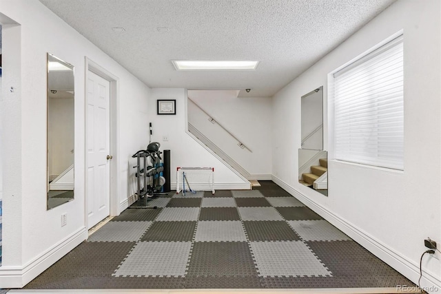 4231 S Fairplay Cir # E, Aurora, CO 80014 - hallway featuring a textured ceiling, stairs, and baseboards