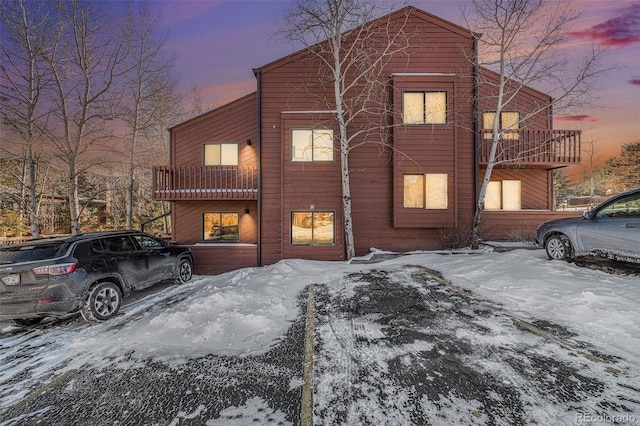 snow covered property with a balcony