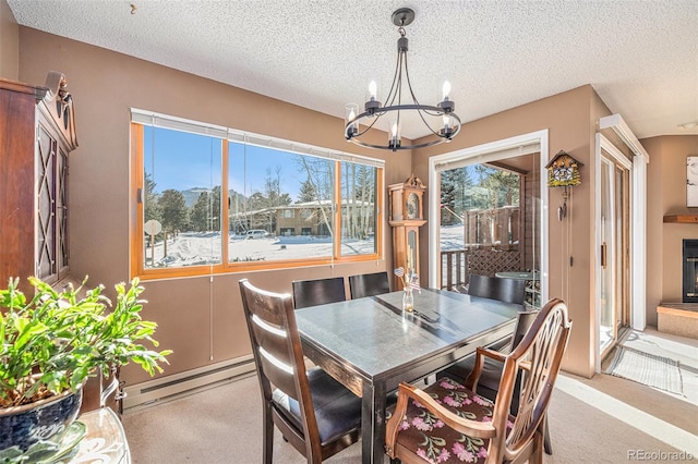 dining room with a baseboard radiator, light colored carpet, a textured ceiling, and a chandelier