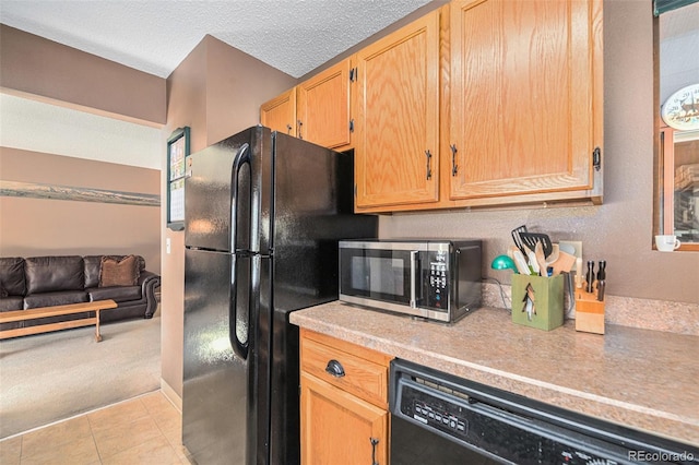 kitchen featuring light tile patterned floors, black appliances, and a textured ceiling