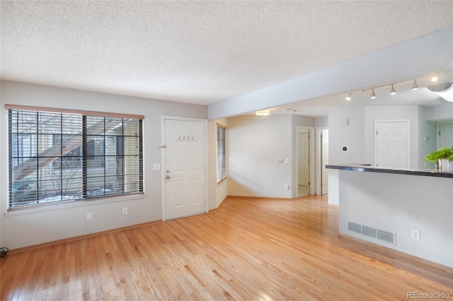 interior space featuring a textured ceiling and light wood-type flooring