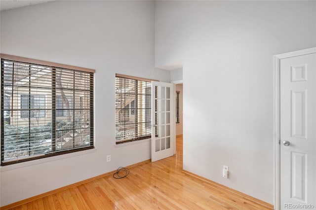 empty room with a towering ceiling and light wood-type flooring