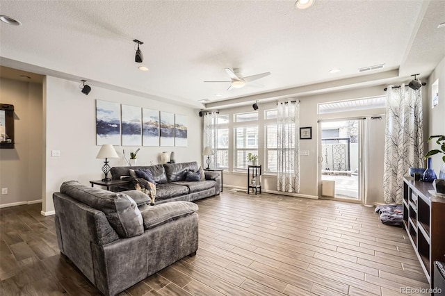 living room with ceiling fan and a textured ceiling