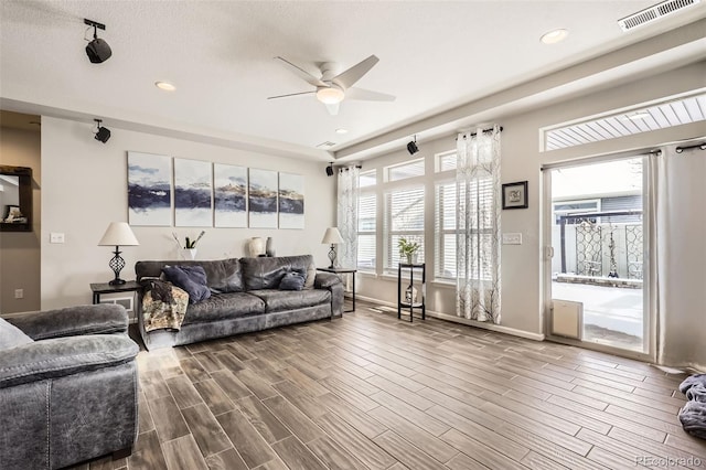 living room featuring ceiling fan and a textured ceiling