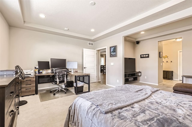 bedroom with light colored carpet and a raised ceiling