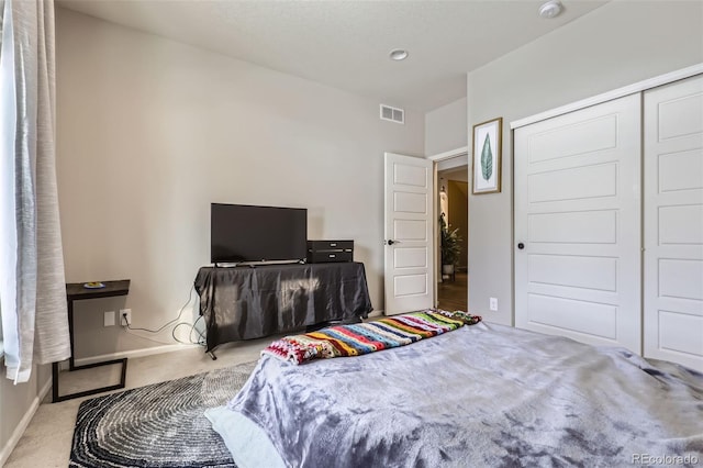 bedroom featuring light carpet and a closet