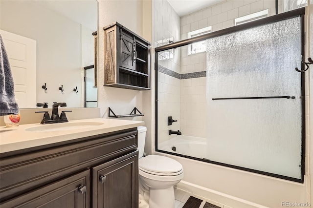 full bathroom with vanity, toilet, and enclosed tub / shower combo