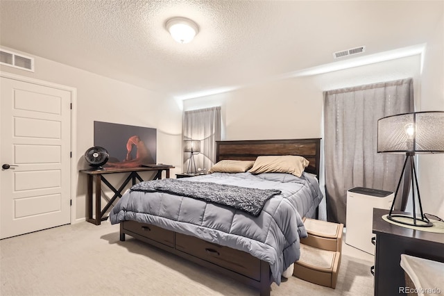 bedroom with a textured ceiling and light colored carpet