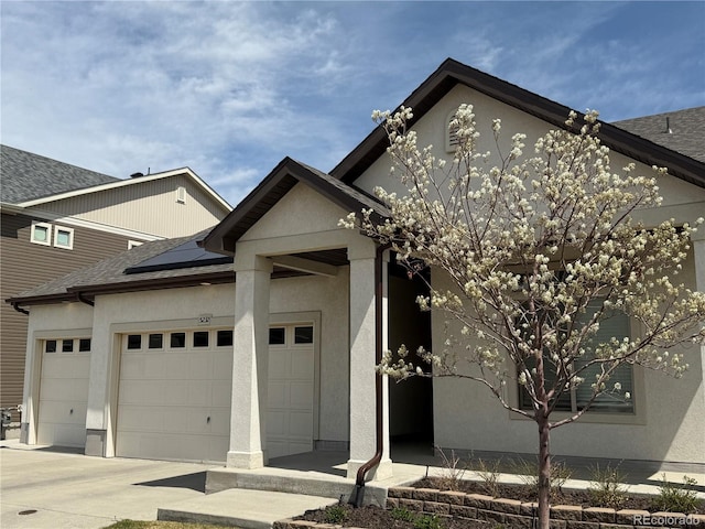 5232 Truckee St, Denver, CO 80249 - view of front facade featuring stucco siding, roof with shingles, solar panels, and a garage