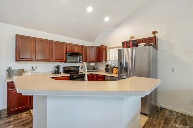 kitchen with hardwood / wood-style floors, a center island, vaulted ceiling, and stainless steel appliances