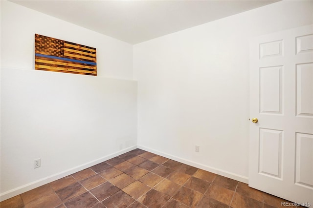 spare room featuring dark tile patterned flooring