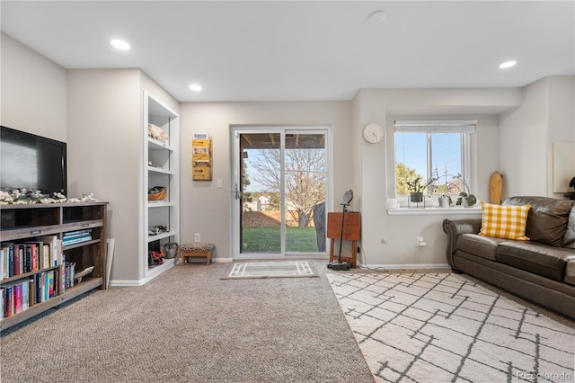 carpeted living area featuring baseboards and recessed lighting