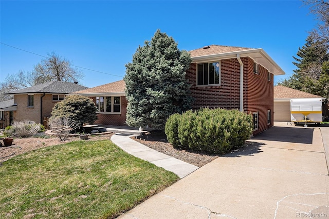 view of front of home featuring brick siding, a front lawn, driveway, and a shingled roof