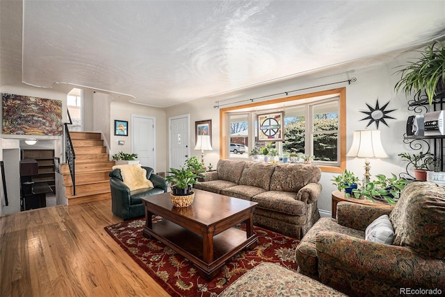 living area with wood finished floors and stairway