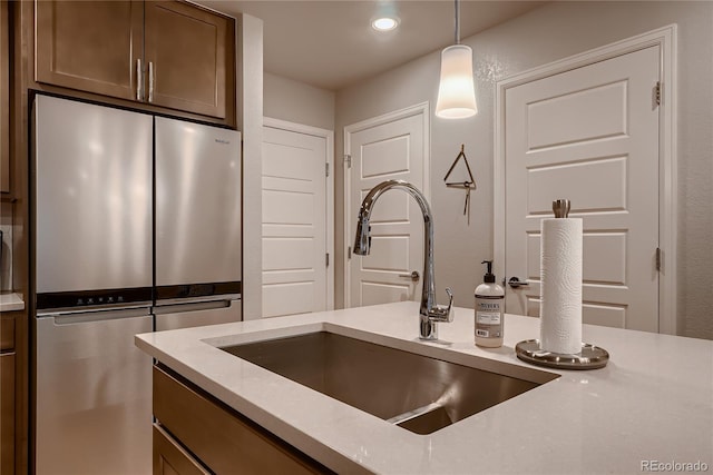 6309 N Hanover St, Denver, CO 80238 - kitchen with stainless steel fridge, a sink, decorative light fixtures, recessed lighting, and light stone countertops