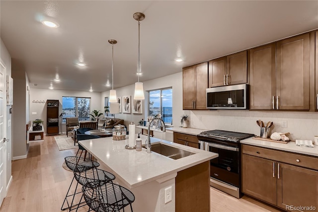 6309 N Hanover St, Denver, CO 80238 - kitchen with stainless steel appliances, a sink, light wood finished floors, open floor plan, and recessed lighting